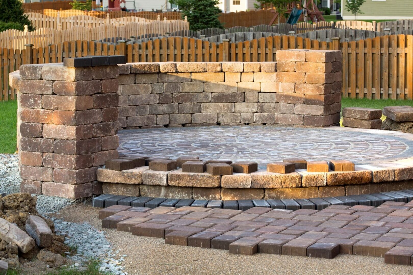 A brick patio with steps and a stone wall.